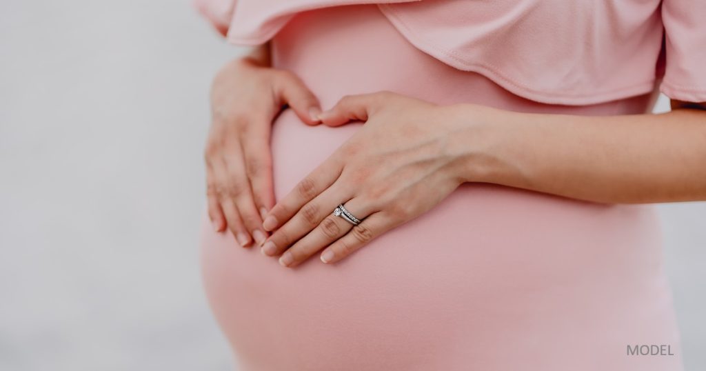 Pregnant woman with hands on her belly