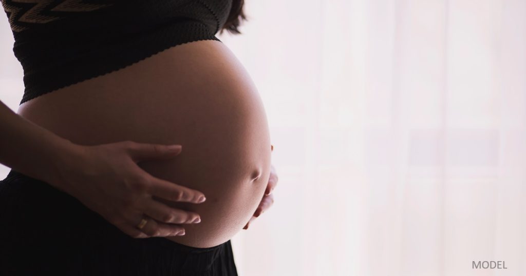 Pregnant woman with hands on her belly