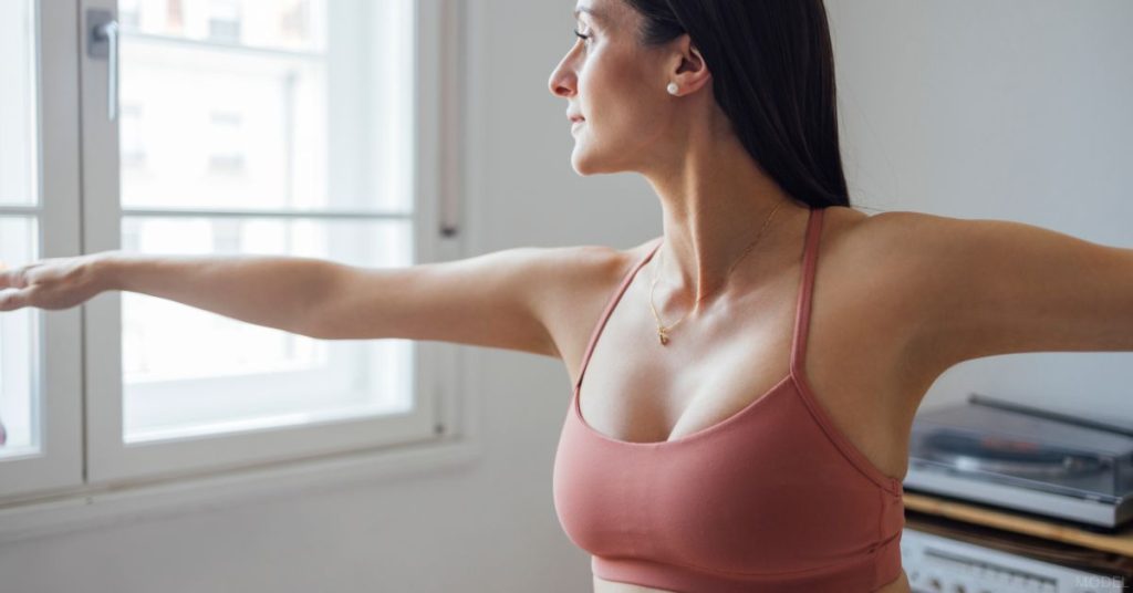 Woman wearing a sports bra and doing yoga (model)